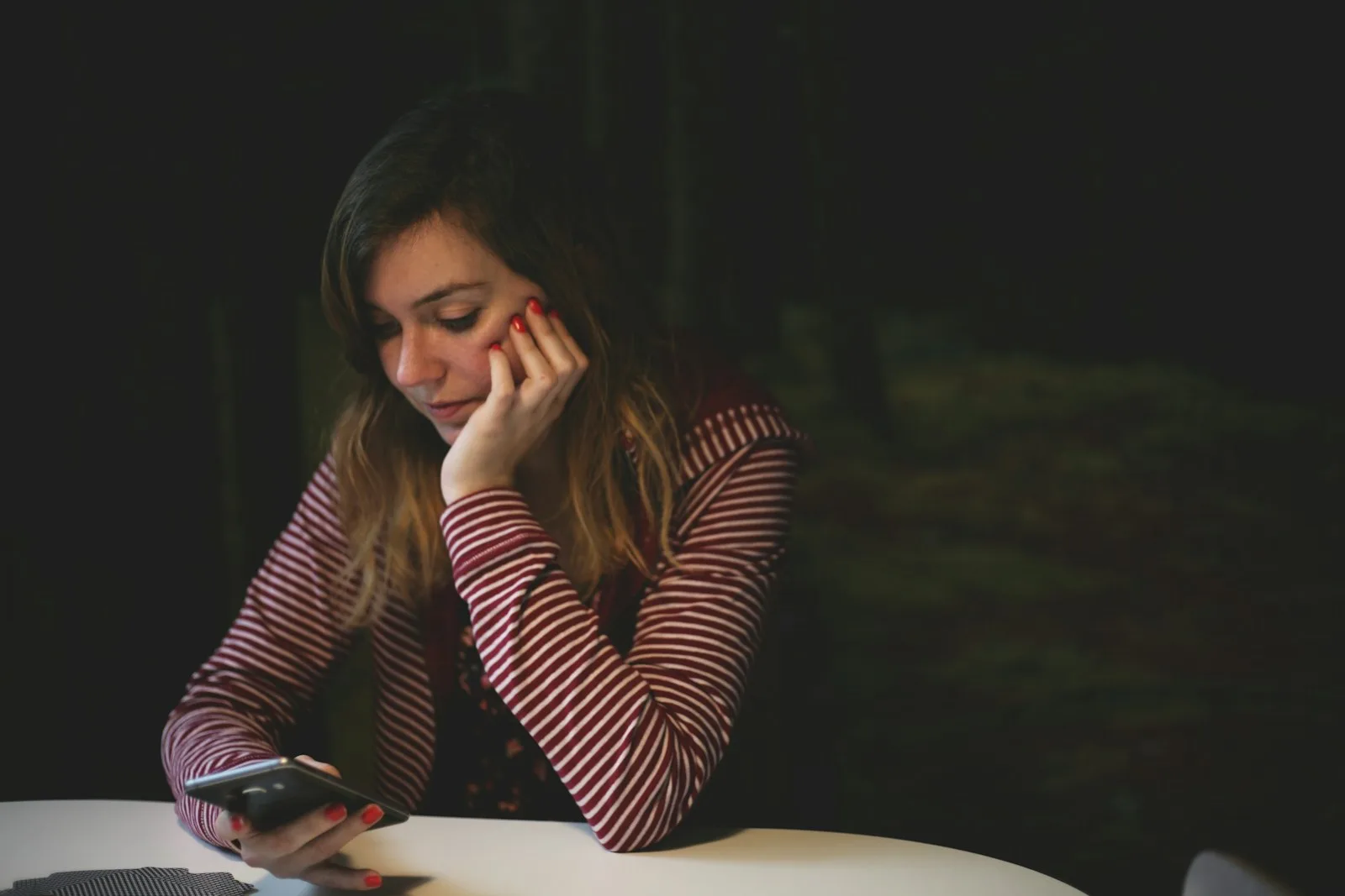 Woman thoughtfully looking at her phone